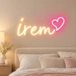 Açık tonlu yatak odasında günışığı İrem LED neon yazısı ve pembe kalp