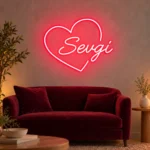 Bordo kanepenin üzerindeki açık renk duvarda kırmızı kalp figürü ve Sevgi yazılı LED neon tabela