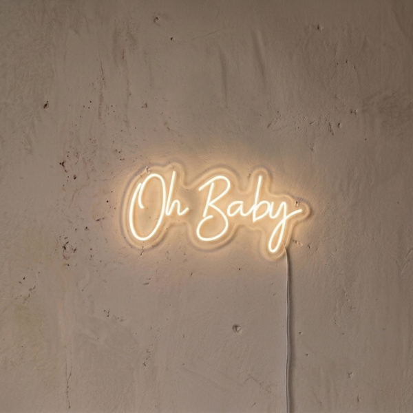 Açık renkli dokulu duvarda sıcak beyaz ışıkla tek satır Oh Baby yazılı LED neon tabela